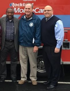 L-R: Renold Julien, Ray Florida, and Pat Withers stand in front of the ambulance being donated to the Haiti relief efforts.